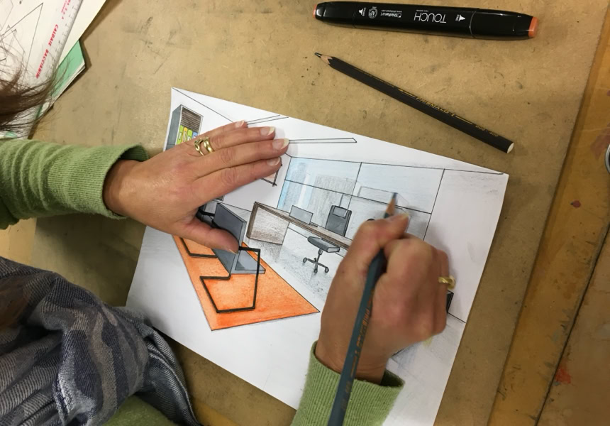 Des mains en train de dessiner avec des crayons de couleur.