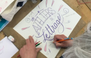 Personne faisant de la calligraphie sur une feuille de papier avec des crayons, avec les mots "ATELIERS de lettrage" visibles.